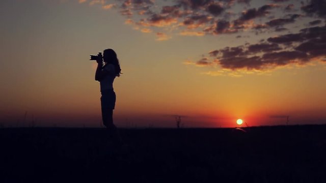 silhouette of girl photographed on sunset background