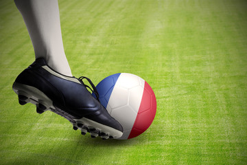 Foot kicking soccer ball at the grass field