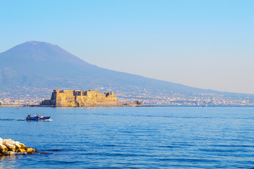 Castel dell'Ovo (italian for the "Egg fortress") in the port of Naples, Italy with volcano Vesuvius 
