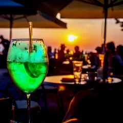  A glass of cold green cocktail at the sunset on the table of a beach bar © t0m15