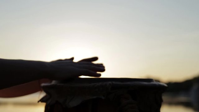 игра на джембе или атабаке на фоне природы во время заката