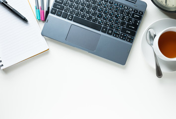 Office table with coffee cup, computer and flower. View from above with copy space