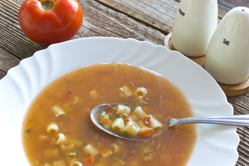 Minestrone soup in plate on wooden table