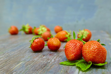 fresh red strawberries with leaves on dark background