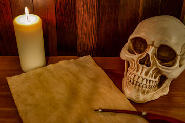 Candle lit scene of a skull, aged paper with a pentagram wax seal on it and a red feather fountain...