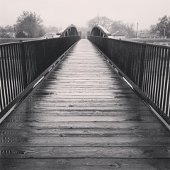 Fototapeta na wymiar Wooden bridge over river in rain