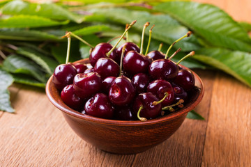 Fresh cherries in bowl on table