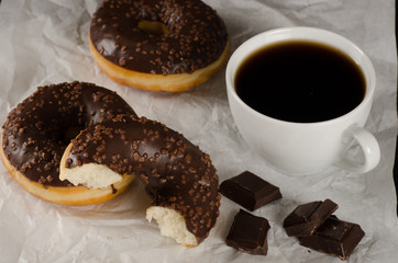 chocolate donuts with coffee and chocolate pieces on crumbled ba