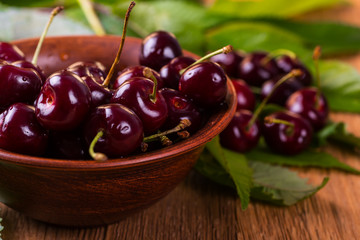Fresh cherries in bowl on table