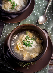 Two ceramic bowls with meat dumplings on wooden table.