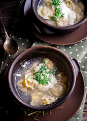 Two ceramic bowls with meat dumplings on wooden table.