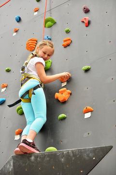 Youngster l'effort en escaladant un mur pour atteindre le sommet