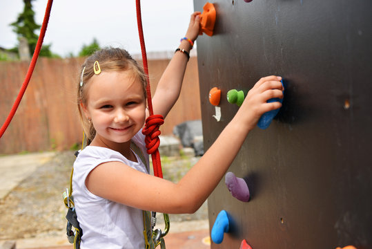Youngster l'effort en escaladant un mur pour atteindre le sommet
