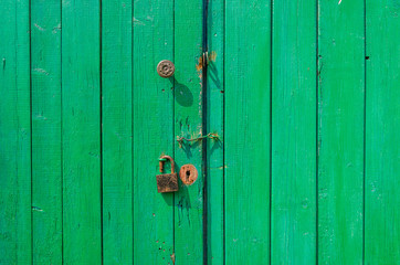 green old wooden gate/green wooden gate with a padlock and the handle