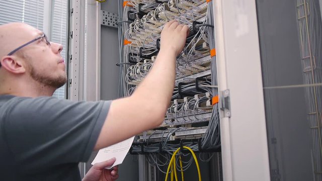 IT guy checks telephone patch panels