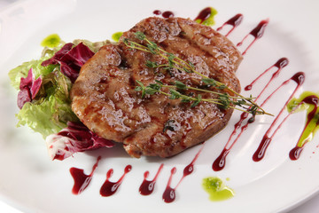 piece of meat on plate with sauce