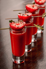 Strawberry alcohol shots with freshly ground pepper.