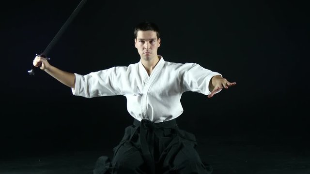 sportsman in a kimono practicing with a sword
