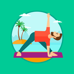 Obraz na płótnie Canvas Man practicing yoga triangle pose on the beach.