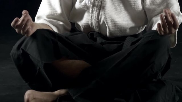 man in a kimono meditates on the floor, slow motion