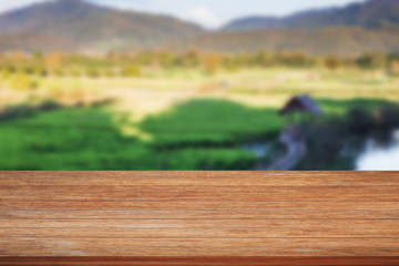 Tabletop wooden with green rice field blurred background