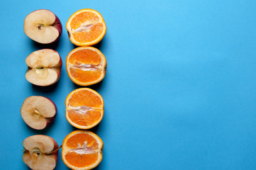 Naklejka na ściany i meble Oranges and apples on blue background