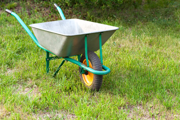 Garden tools on a green lawn. Wheelbarrow.