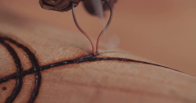 Artist using pyrography to decorate a Buddhist prayer wheel