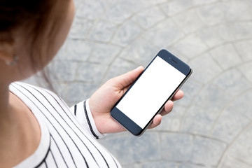 woman looking phone on road in the city, third-person view