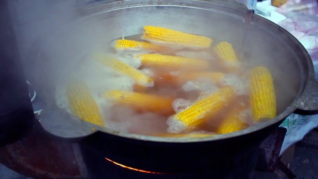 Corn boiled in pan. Street food. Cooking corn in boiled water. Sweet corn preparation. Golden corn boil in water. Water steam. Healthy vegetable. Cooking corn cobs in large pan with boiled water