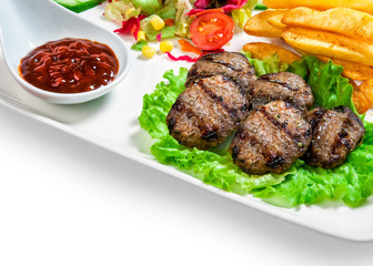 French fries, meatballs on the lettuce, vegetables and barbecue