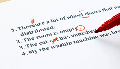 english sentences and correcting symbols on white sheet