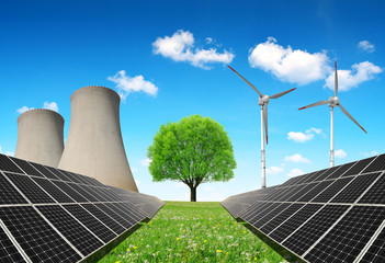 Solar panels before a nuclear power plant and wind turbines. Energy resources concept.