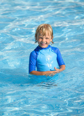 Fototapeta na wymiar Smiling little boy in swimming pool