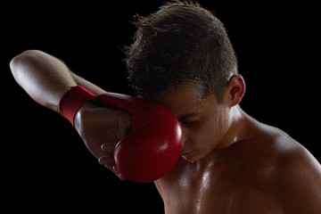 Fototapeta na wymiar Young boy athlete, boxer or kickboxer gloves after training.