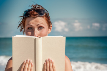 Frau mit Buch am Strand