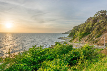 A scenery of road beside mountains and sea with the sunset time in Chanthaburi Thailand.