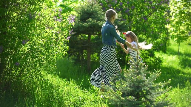 young mother with her daughter playing in a spring park