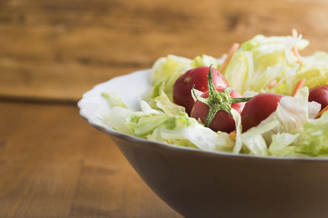 fresh lettuce salad with carrots cut into strips and whole tomatoes.