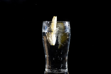 fresh slice of lemon falling in water