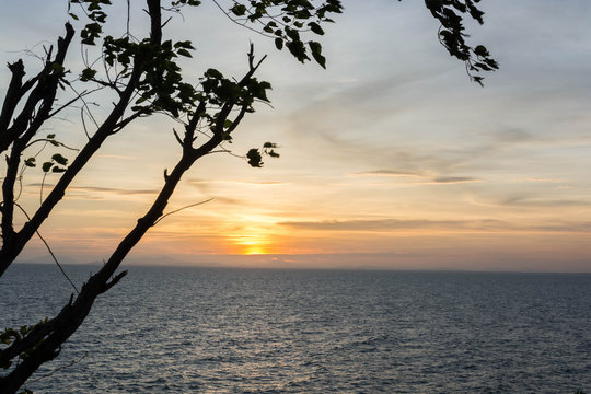 A scenery of sea at sunset with a shadow of tree at the side of photo in Chanthaburi, Thailand.