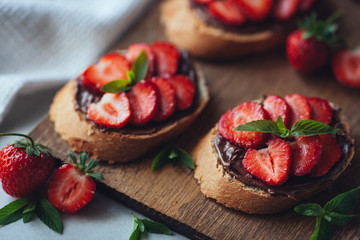 Strawberry bruschetta with chocolate paste and mint.Healthy thre