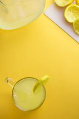 Water and lemon in yellow background