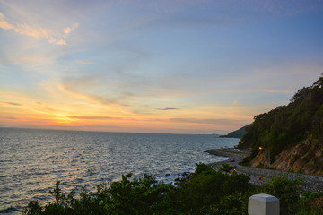 A scenery of road beside mountains and sea with the sunset time in Chanthaburi Thailand.