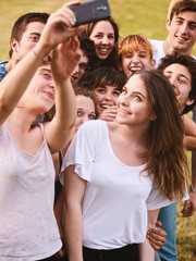 large group of friends together in a park having fun and taking a selfie