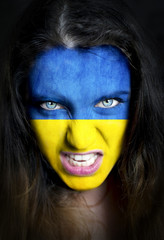 Soccer fan with Ukraine flag painted over face