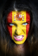 Portrait of a woman with the flag of the Spain  painted on her face