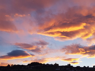 Fototapeta premium Colorful sunset clouds in the sky above an urban area on a ridge