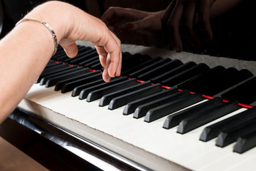 Obraz premium Mani di pianista sulla tastiera del pianoforte durante un’esecuzione