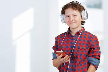 attracive kid is listening music with headphones